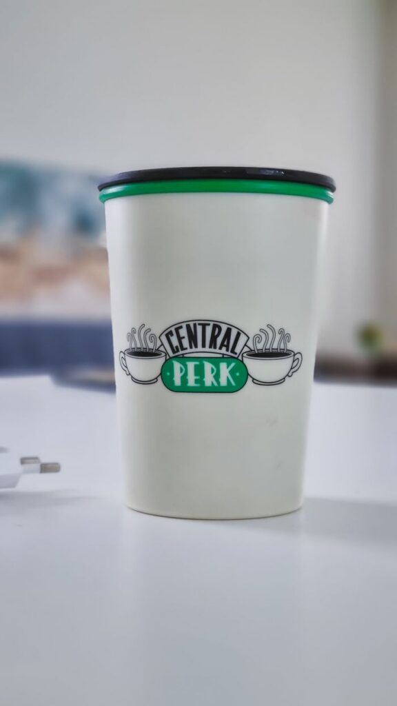 A Central Perk branded coffee cup sits on a table, evoking a classic cafe vibe.