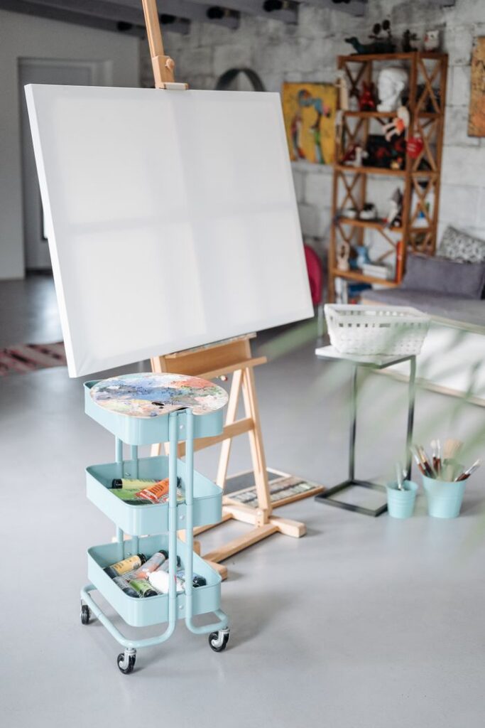 Bright art studio featuring an easel with a blank canvas and art supplies ready for creativity.